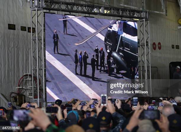 Members of the U.S. Navy and shipyard workers watch as U.S. President Donald Trump steps off of Marine One onto the deck of USS Gerald R. Ford CVN 78...