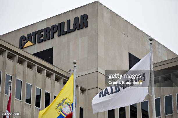 Flags fly outside Caterpillar Inc. Headquarters in Peoria, Illinois, U.S., on Thursday, March 2, 2017. Caterpillar Inc. Shares headed for the...