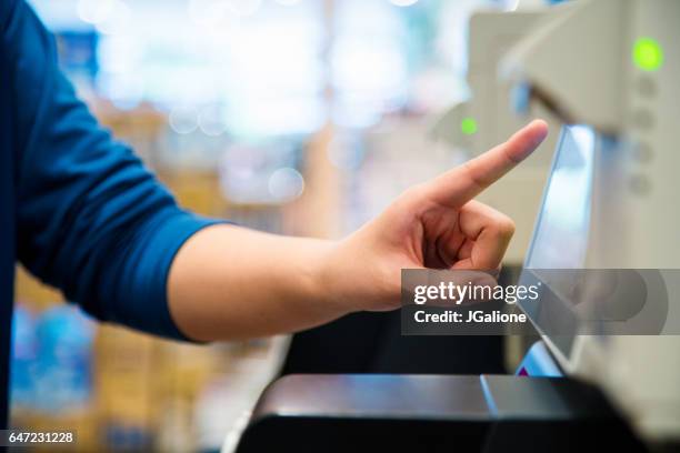 close up of a woman using a self checkout machine - self service stock pictures, royalty-free photos & images