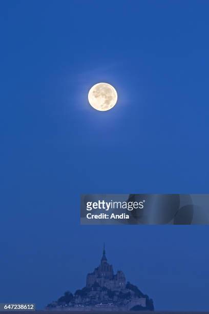 Equinox, full moon over Le Mont-Saint-Michel . .