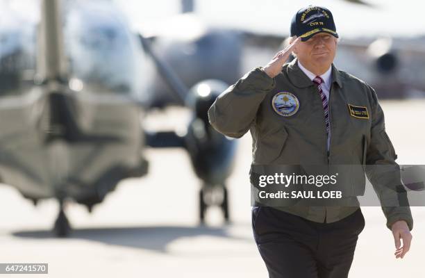 President Donald Trump salutes as he walks to Air Force One prior to departing from Langley Air Force Base in Virginia, March 2 as he traveled to...