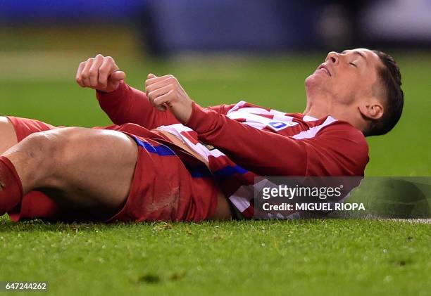 Atletico Madrid's forward Fernando Torres lies on the field after loosing a chance to score during the Spanish league football match RC Deportivo de...