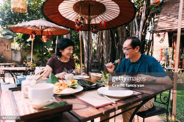 mature couple enjoy lunch on their vacations in southeast asia - chang mai stock pictures, royalty-free photos & images