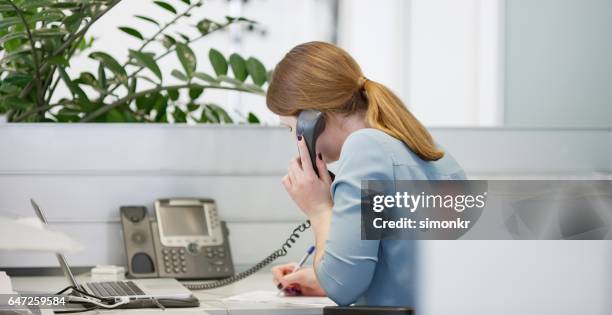 mujer joven trabajando en la oficina - teléfono con cable fotografías e imágenes de stock