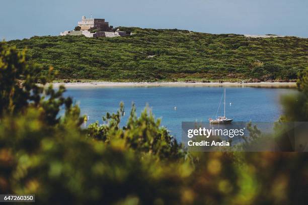 Hyeres , Porquerolles Island, June 2013: Landscape on the seaside. White beach, sailboat lying at anchor and fort