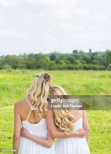two women comforting each other in nature - white dress stock pictures, royalty-free photos & images