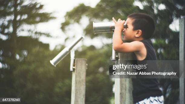 kid looking through binaculars. - summer camping new zealand stock pictures, royalty-free photos & images