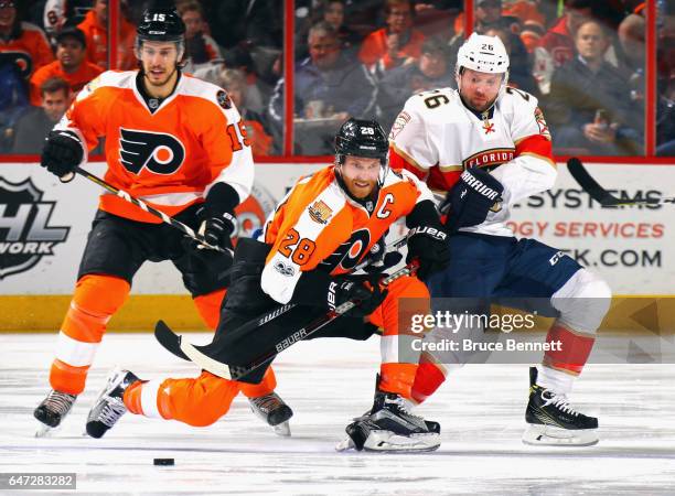 Claude Giroux of the Philadelphia Flyers is checked by Thomas Vanek of the Florida Panthers during the second period at the Wells Fargo Center on...