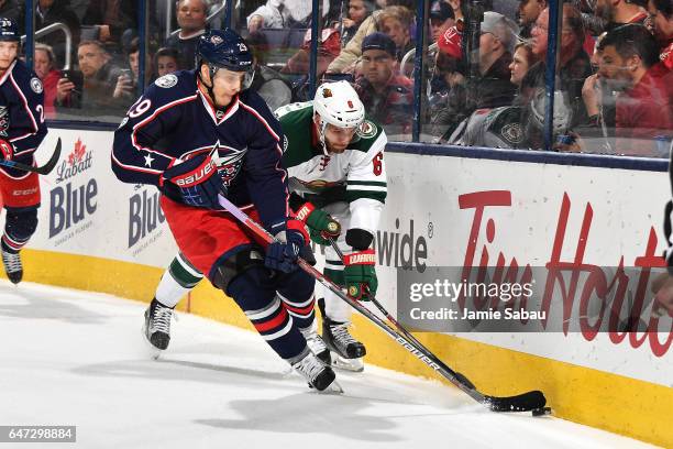 Lauri Korpikoski of the Columbus Blue Jackets attempts to skate the puck away from Marco Scandella of the Minnesota Wild during the third period of a...