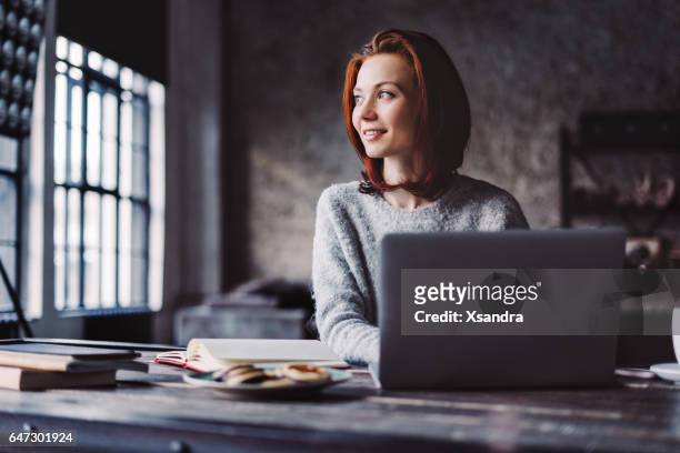 young woman working in a loft apartment with a laptop computer - person horizontal ideas indoors internet laptop stock pictures, royalty-free photos & images