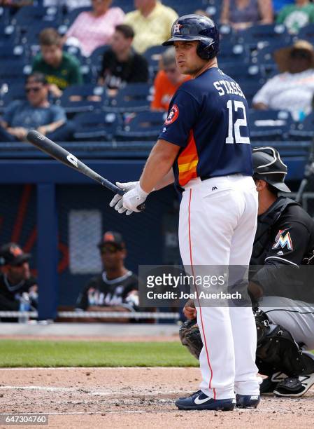 Max Stassi of the Houston Astros looks for his signal prior to batting against the Miami Marlins in the second inning during a spring training game...