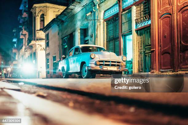 old american car in old havanna street at night - cuba car stock pictures, royalty-free photos & images