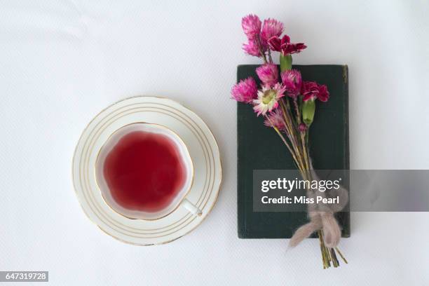 berry tea with wild flowers and old book - tea cup overhead view photos et images de collection