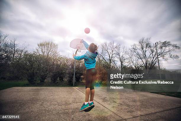 girl jumping, throwing basketball in hoop - usa court stock-fotos und bilder