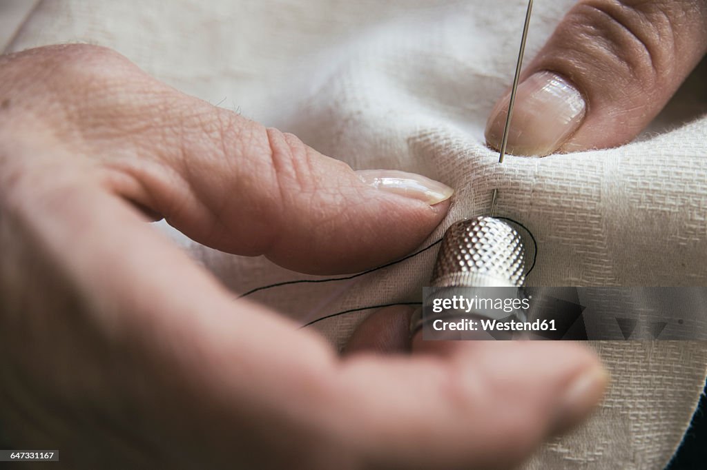 Woman with a thimble sewing