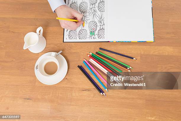 man's hand with colouring book and coloured pencils - milch von oben stock-grafiken, -clipart, -cartoons und -symbole