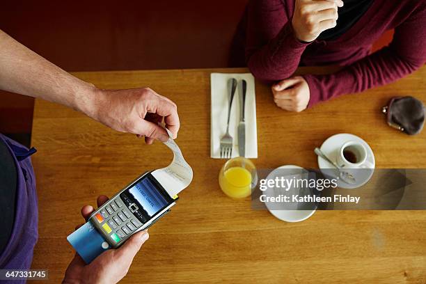 overhead cropped view of waiter removing receipt from credit card machine in restaurant - receipt 個照片及圖片檔