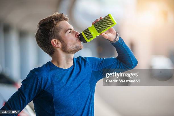 young sporty man with water bottle - running refreshment stock pictures, royalty-free photos & images