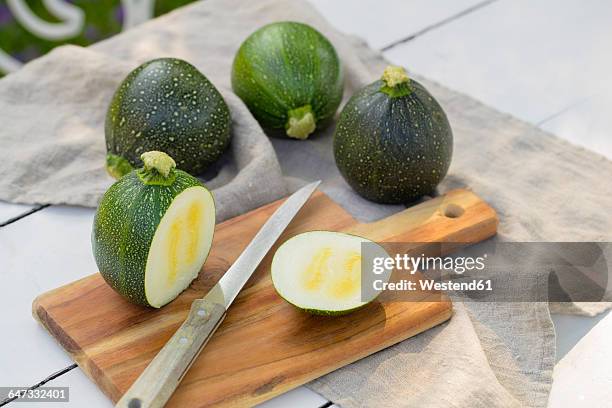 sliced and whole eight ball squashes - calabacín fotografías e imágenes de stock