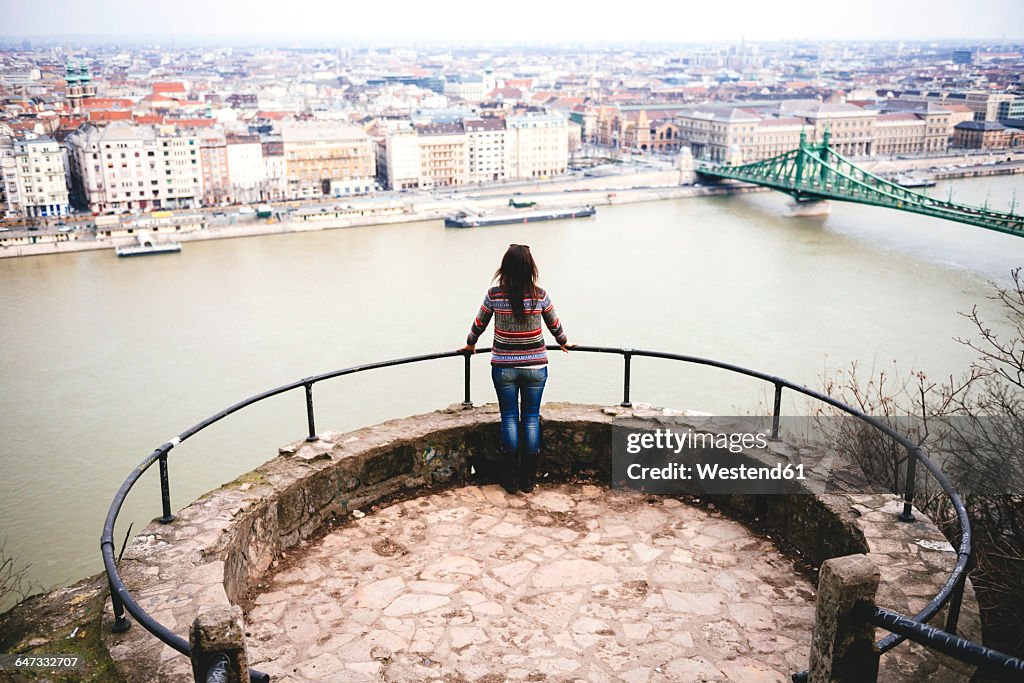 Hungary, Budapest, Woman enjoying the view with Liberty Bridge at Danube river