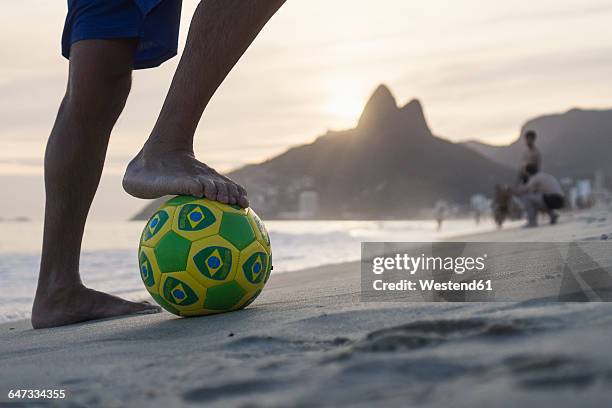 brazil, rio de janeiro, man standing with ball on ipanema beach - ipanema beach stock pictures, royalty-free photos & images