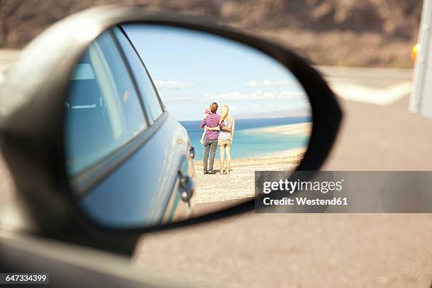 spain, fuerteventura, jandia, reflection of family at the coast in wing mirror of a car - specchietto di veicolo foto e immagini stock