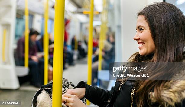 uk, london, happy young woman in an underground train - london underground train stockfoto's en -beelden