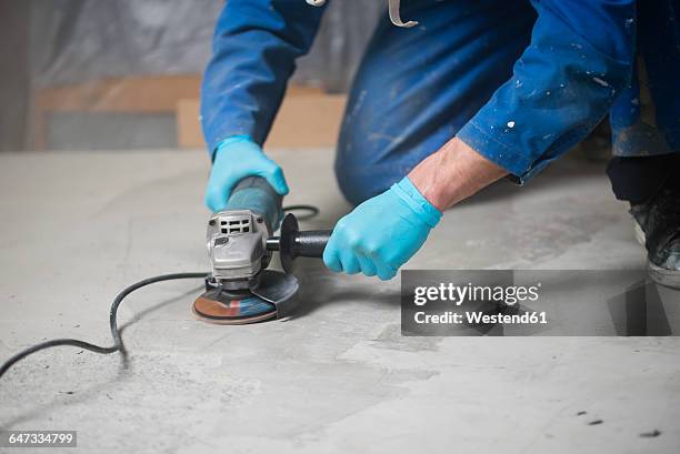 worker smoothening cement with an angle grinder - grinder stockfoto's en -beelden