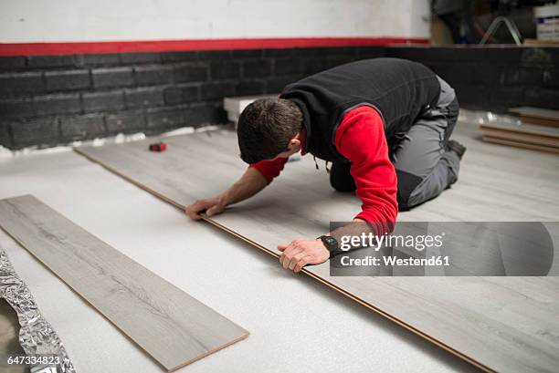 young man placing a laminate floor - laminiertes plastik stock-fotos und bilder