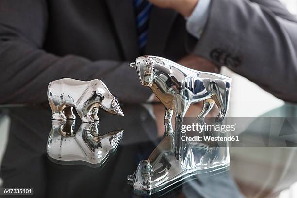 businessman observing stock market, bull and bear figurines - bull bear stock pictures, royalty-free photos & images