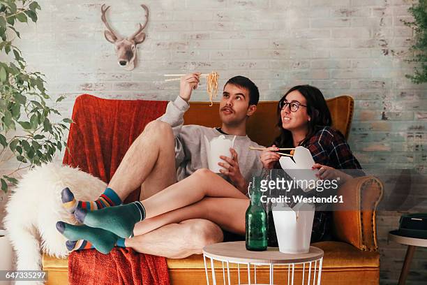 young couple eating chinese take-away food at home - noodles eating stock pictures, royalty-free photos & images