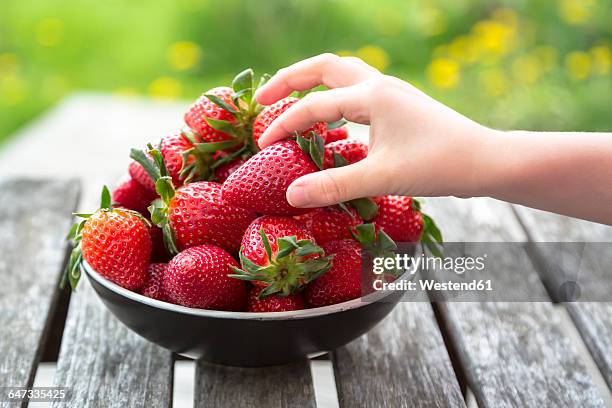 girl's hand taking strawberry - fruit bowl stock pictures, royalty-free photos & images