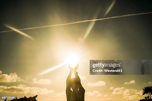 boy playing with the sun - sunset with jet contrails stock pictures, royalty-free photos & images