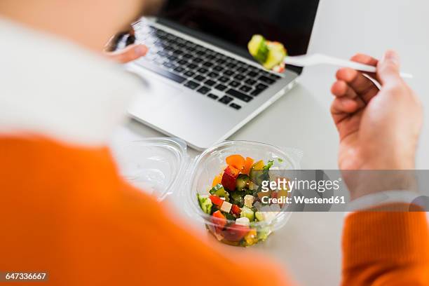 young man having a salad at desk in office - healthy working stock pictures, royalty-free photos & images