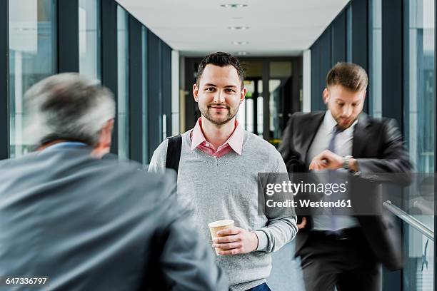 calm businessman in contrast to businessmen in a hustle - checking watch stock pictures, royalty-free photos & images