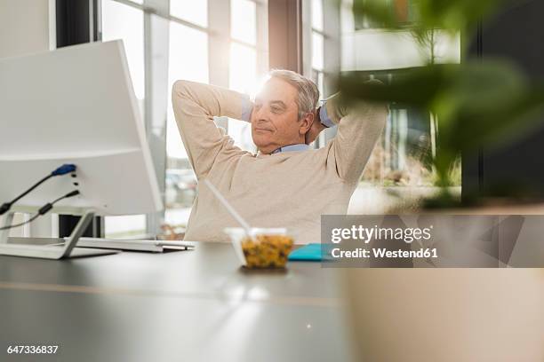 senior man in office, during break - recostarse fotografías e imágenes de stock