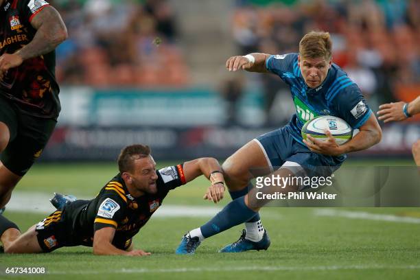 Piers Francis of the Blues is tackled by Aaron Cruden of the Chiefs during the round two Super Rugby match between the Chiefs and the Blues at Rugby...