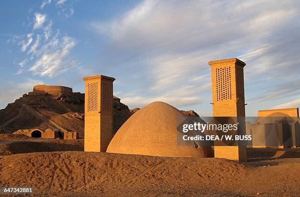 Zoroastrian building with badgirs with the Tower of Silence in the background on the left, near Yazd, Iran.