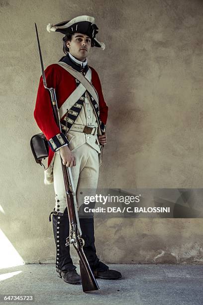 Redcoat, British army soldier with tricorn hat and muzzle-loading rifle. American Revolutionary War, 18th century. Historical reenactment.