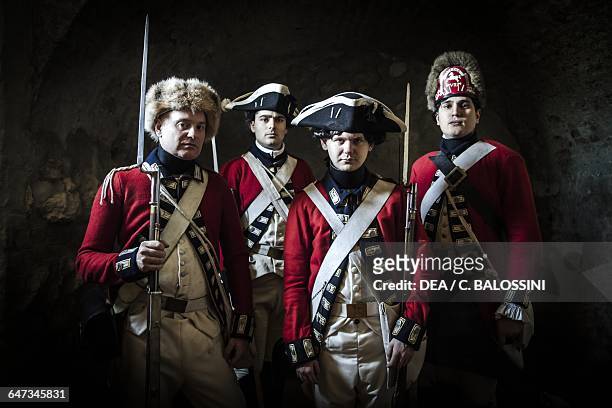 Redcoats, British army soldiers with tricorn hats, fur hats and muzzle-loading rifles. American Revolutionary War, 18th century. Historical...