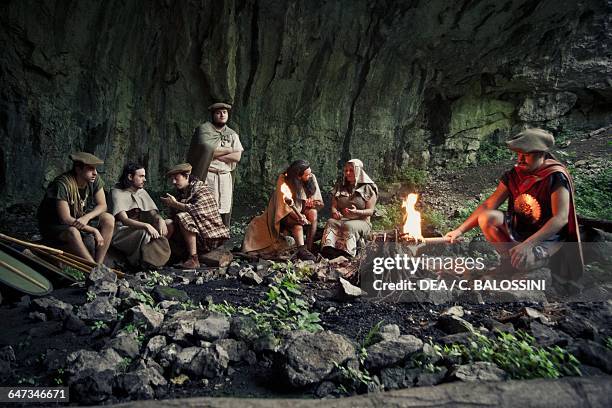 Group of warriors sheltering in a cave at nght and lighting a fire, Illyrian civilisation, mid-3rd century BC. Historical reenactment.