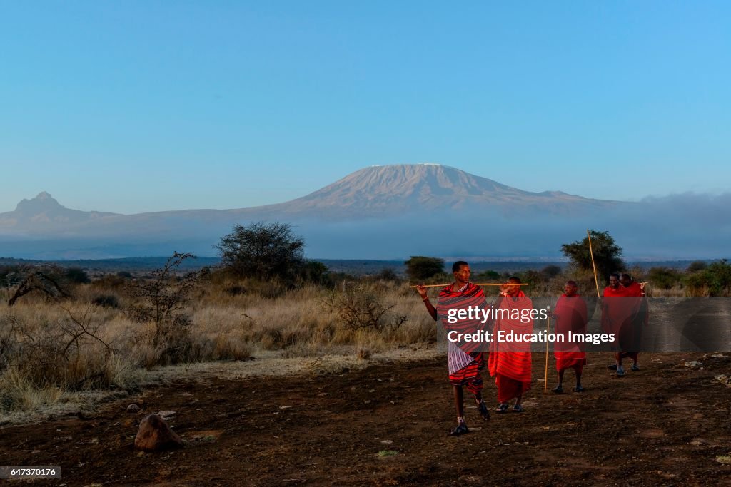 Maasai, Masai, elders with Mt Kilimanjaro and Mt Mawenzi, in Tanzania, on the left in the background, Kenya.