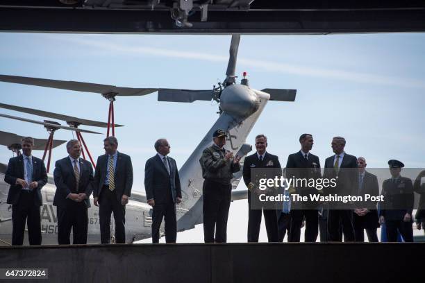 President Donald Trump, center, rides an elevator to the flight deck after speaking aboard nuclear aircraft carrier Gerald R. Ford at Newport News...