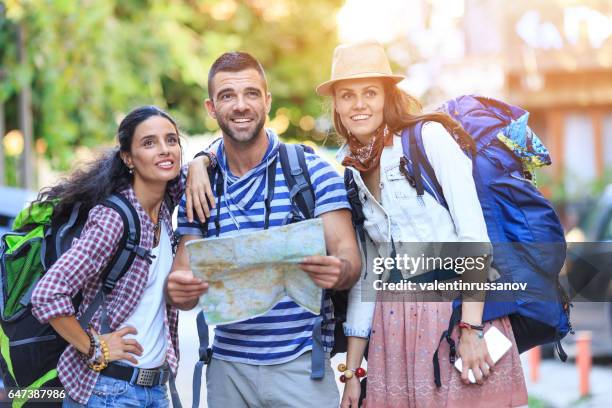 backpacker mit hilfe einer karte auf straße - orientierungslauf landkarte gruppe stock-fotos und bilder