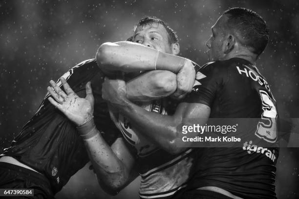 Josh Morris of the Bulldogs is tackled during the round one NRL match between the Canterbury Bulldogs and the Melbourne Storm at Belmore Sports...