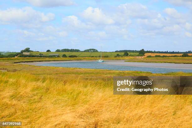 Butley Creek river landscape, Boyton, Suffolk, England, UK with moored yacht.