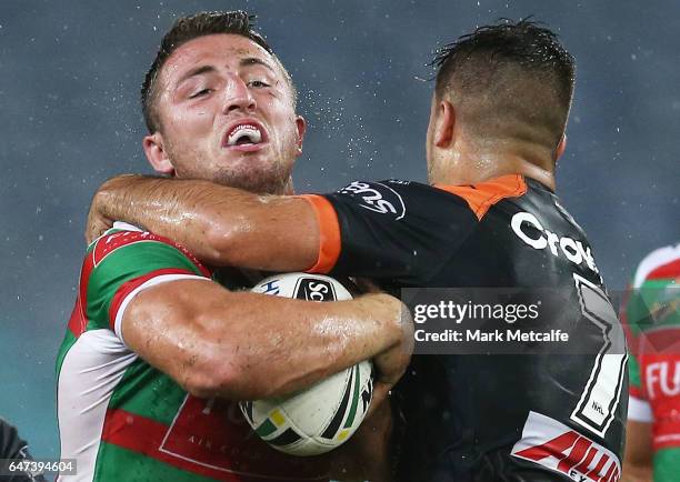 Sam Burgess of the Rabbitohs is tackled by Luke Brooks of the Tigers during the round one NRL match between the South Sydney Rabbitohs and the Wests...