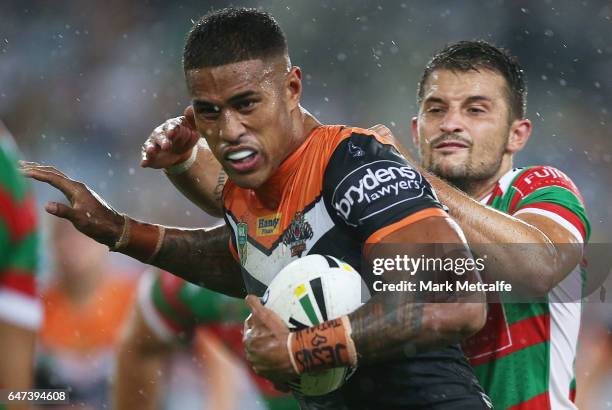 Michael Chee-Kam of the Tigers is tackled during the round one NRL match between the South Sydney Rabbitohs and the Wests Tigers at ANZ Stadium on...