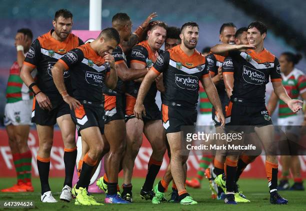 Chris Lawrence of the Tigers celebrates scoring a try with team mates during the round one NRL match between the South Sydney Rabbitohs and the Wests...