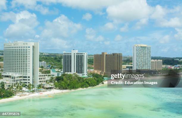 Guam USA Territory Tumon Bay hotels and beach from above with ocean beach and clouds.